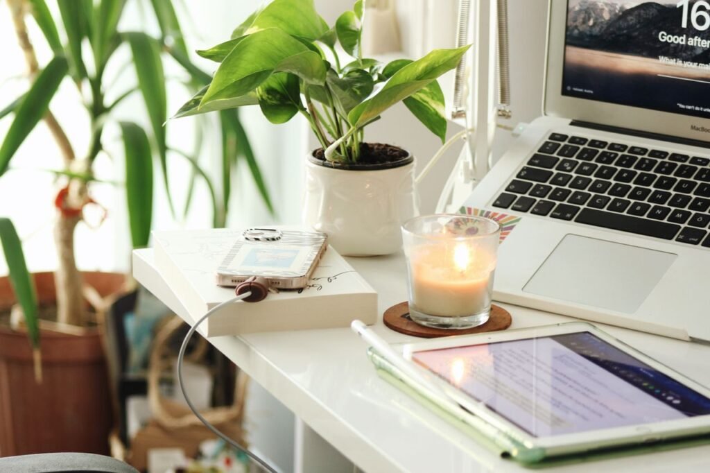 10 Low-Stress Jobs That Still Pay Well in the US A serene home office desk setup with a laptop, candle, and plants creating a peaceful ambiance.
