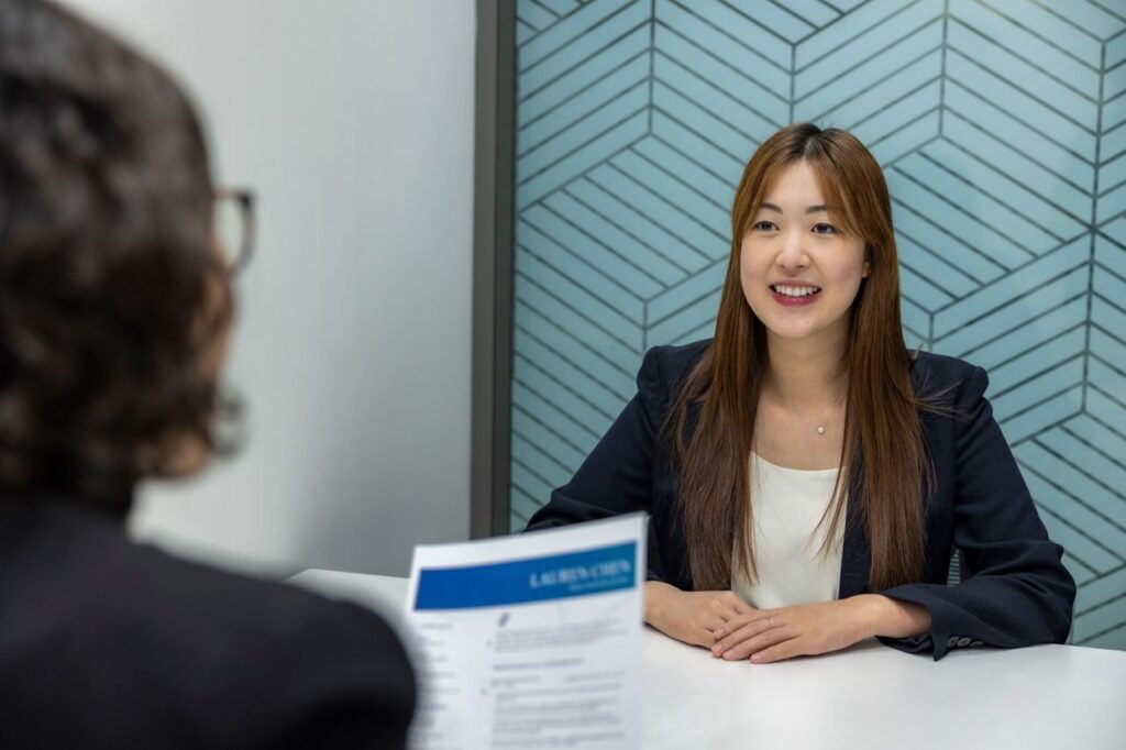 Top 7 Common US Job Interview Questions and How to Answer Them Young woman in a business meeting with an interviewer, showcasing confidence and professionalism.