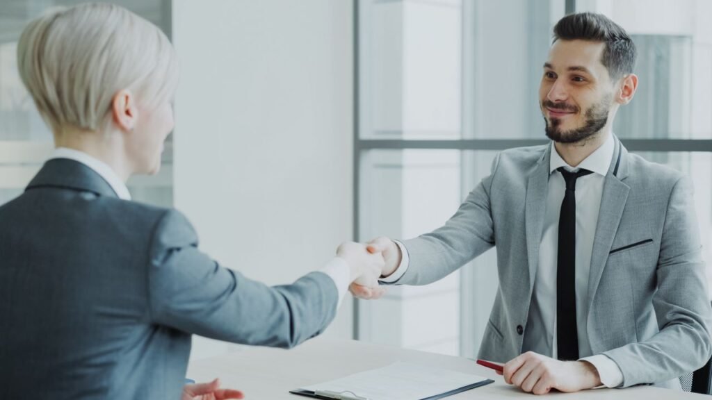 How the California State Government Hiring Process Actually Works Two professionals shaking hands in a bright, modern office environment.
