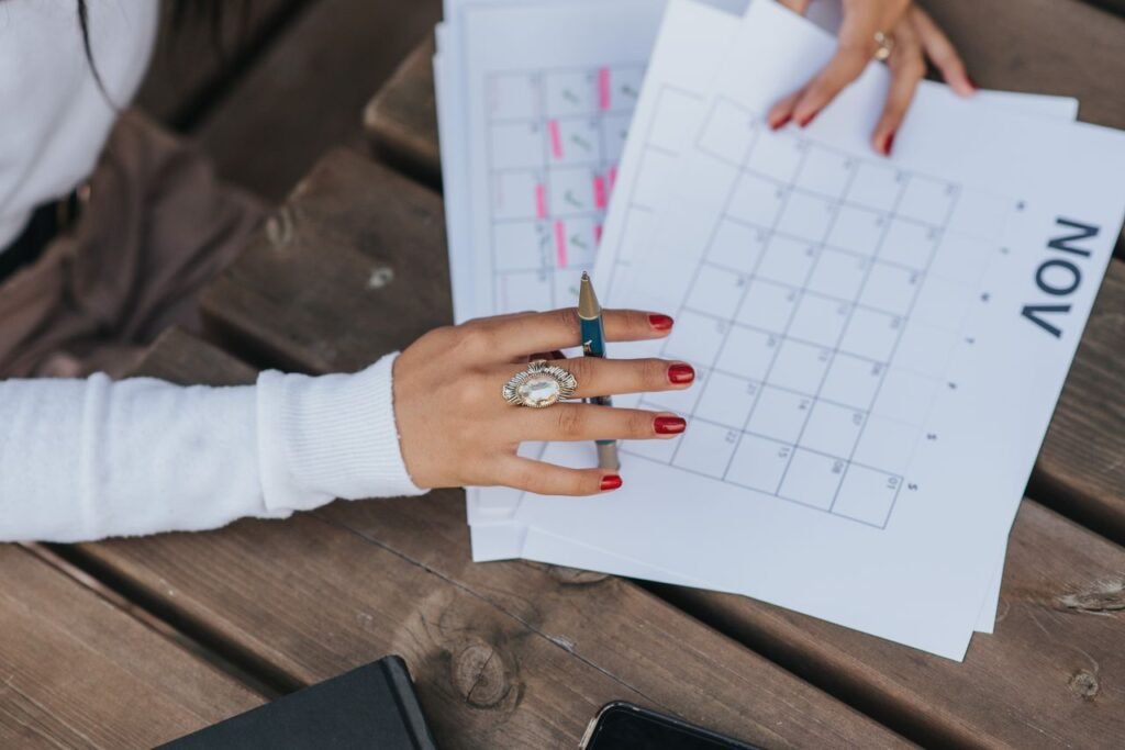 How Long Should You Stay at a Job Before Looking for a New One? From above crop anonymous female in white blouse sitting at wooden table with pen and making list of plans for month