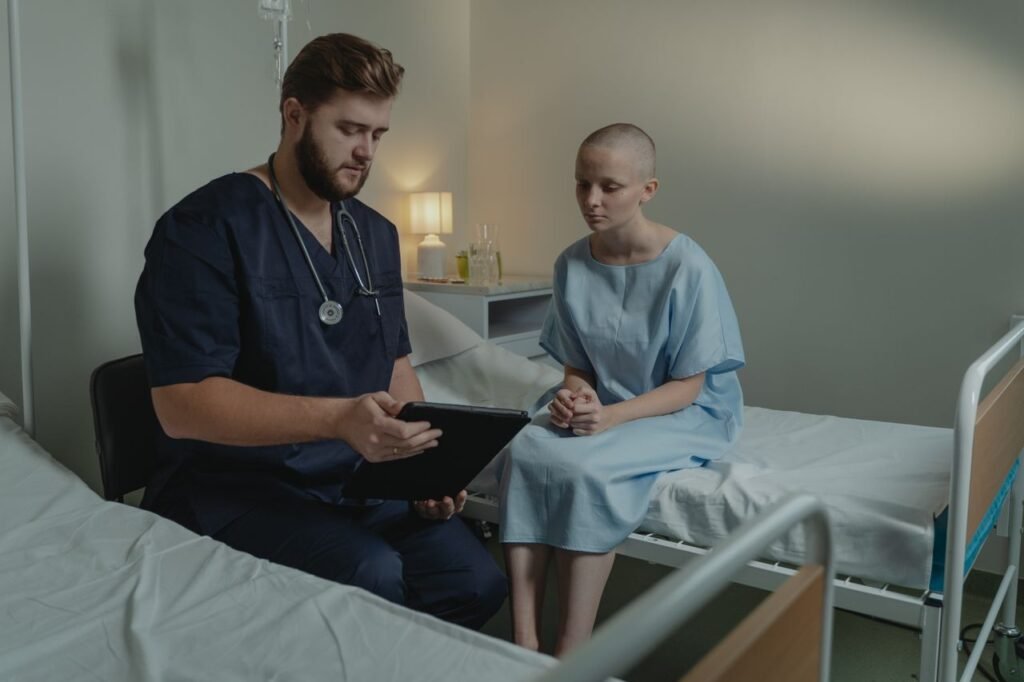 8 Jobs That Are Likely to Stay Safe From AI (2026 Guide) A doctor in a hospital ward consulting a patient with a digital tablet.