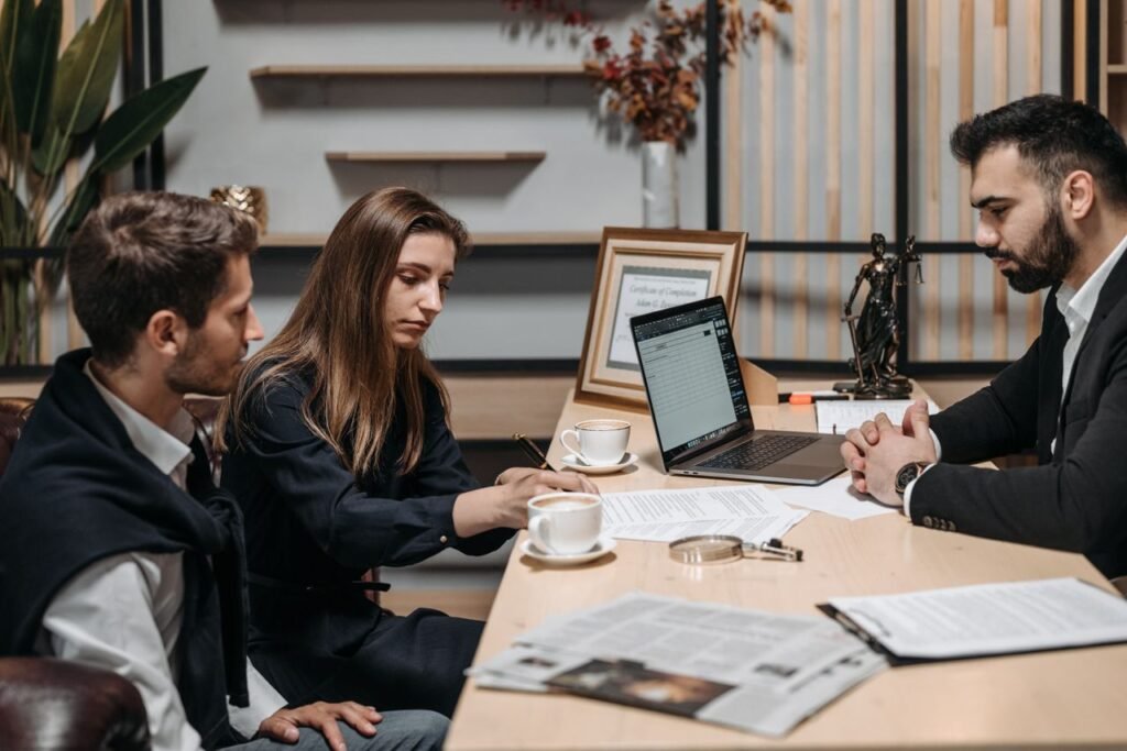 How to Negotiate Your Salary Offer in the US: A Step by Step Guide Three professionals discussing documents over coffee in a modern office setting.